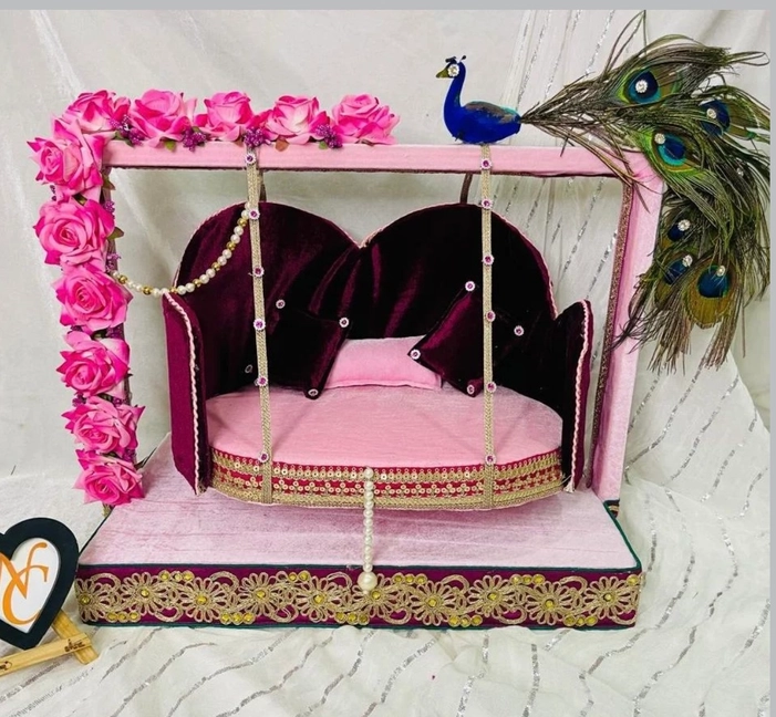 Beautifully Pink And Red crafted wooden swing (jhula) for Laddu Gopal Ji, adorned with peacock feathers
